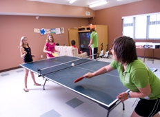 Kids play ping pong in a recreation centre