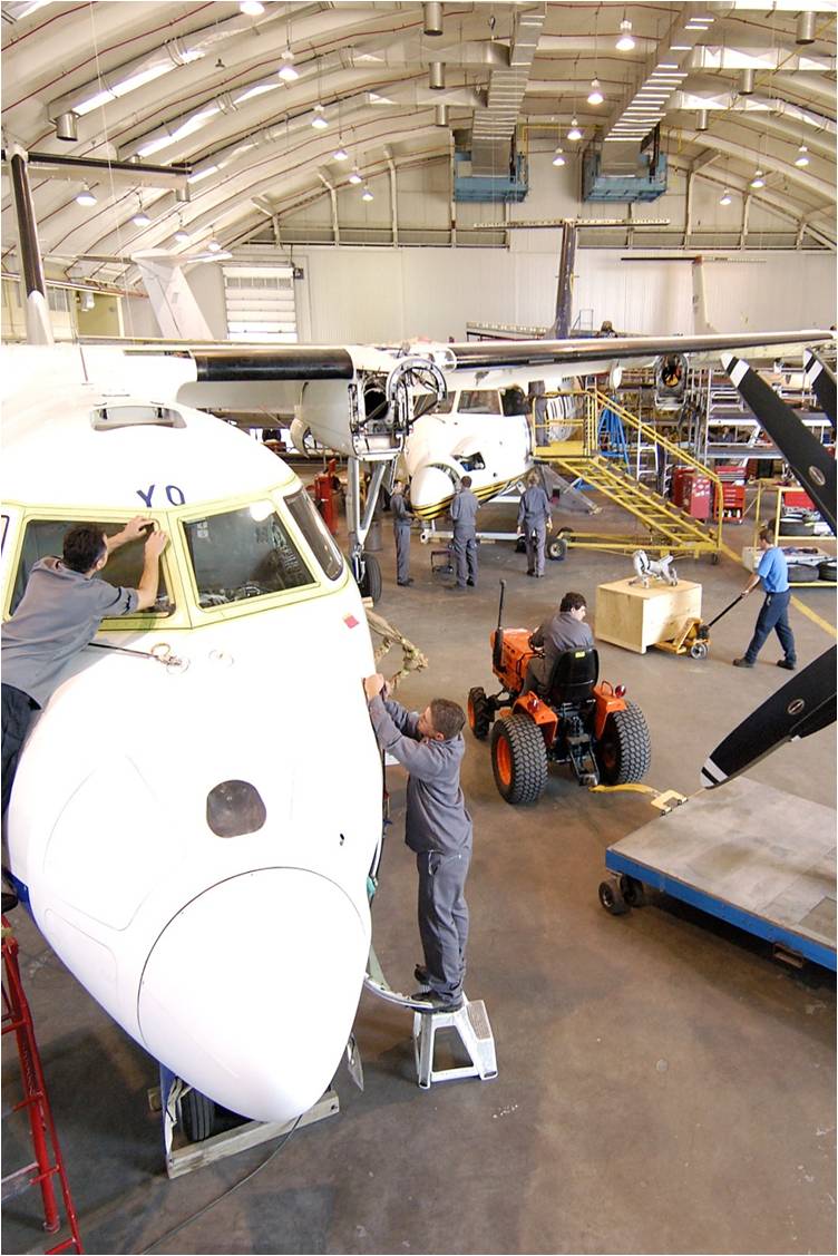 People working in an aircraft maintenance hanger.